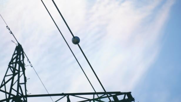 Runde Sensoren an Hochspannungsleitungen überwachen die Temperatur und helfen dabei, die Nutzung von Leitungen zu optimieren.