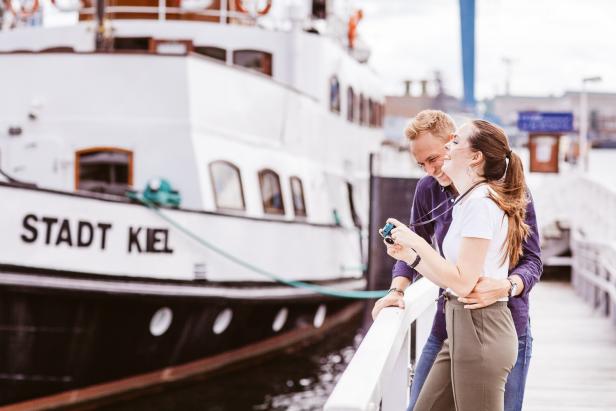 Ein Paar genießt den maritimen Flair am Hafen von Kiel vor dem Ausflugsschiff „Stadt Kiel“.