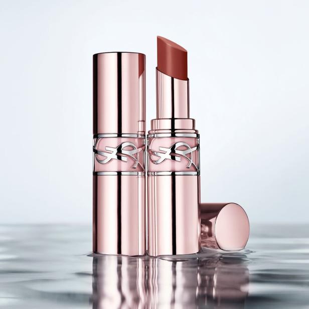 Zwei roségoldene Lippenstifte mit silbernem Logo stehen auf einer glänzenden Oberfläche.