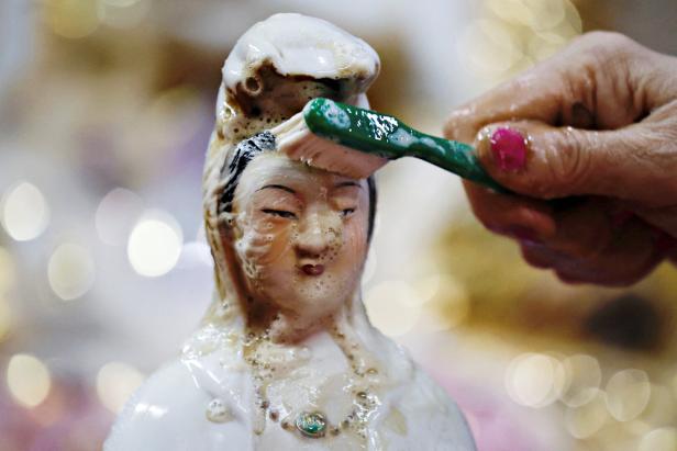 A worshiper brushes a sacred figure statue ahead of the Chinese Lunar New Year celebrations, welcoming the Year of the Horse, at the Amurva Bhumi temple, in Jakarta