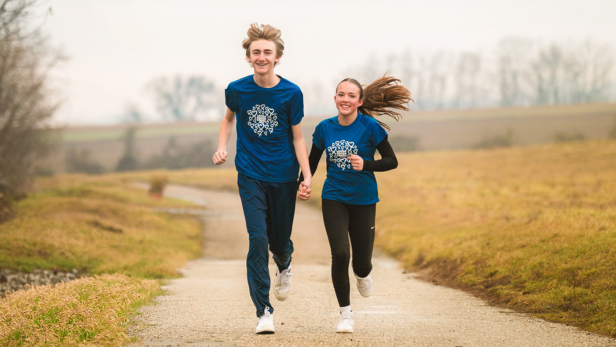 Ein Junge und ein Mädchen laufen Hand in Hand bei Laufen gegen Krebs