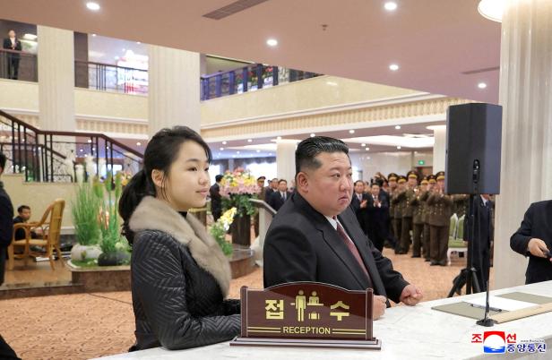 North Korean leader Kim Jong Un and his daughter Kim Ju Ae stand at a hotel reception counter as they attend an inauguration ceremony for hotels in the tourist resort in Samjiyon City