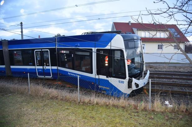 Eine entgleiste Straßenbahn mit beschädigter Front steht neben den Gleisen vor einem Wohnhaus.