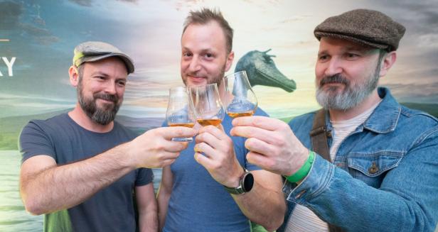 Drei Männer stoßen mit Whisky an