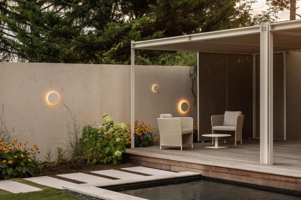 Moderne Terrasse mit Lounge-Möbeln, stimmungsvoller Beleuchtung und Pool im Garten.