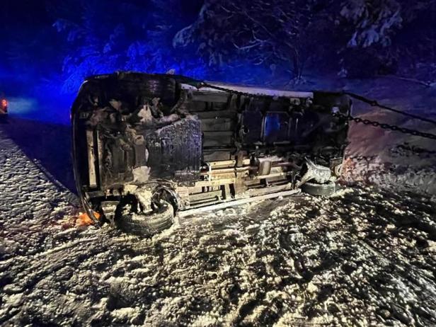 Ein Auto liegt auf der Seite bei winterlichen Bedingungen