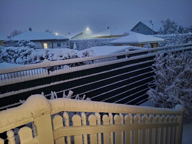 Schnee liegt auf einem Stiegengeländer