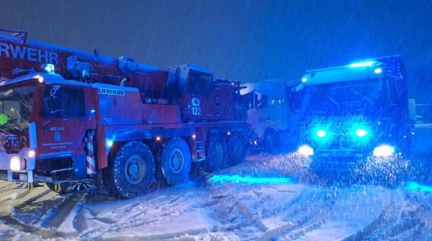 Eine Aufnahme von zwei Feuerwehrautos im Schneetreiben.