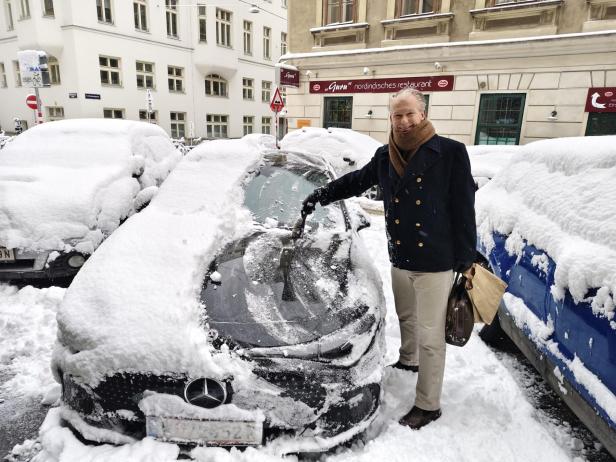 Ein Mann befreit sein Auto vom Schnee