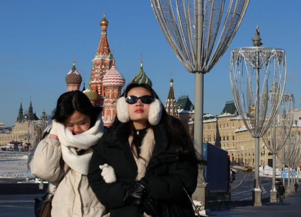 Women walk along a street in Moscow