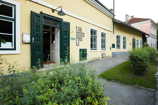 Eine Aufnahme der gelben Fassade samt grünen Türen des Vinzenz Pauli.