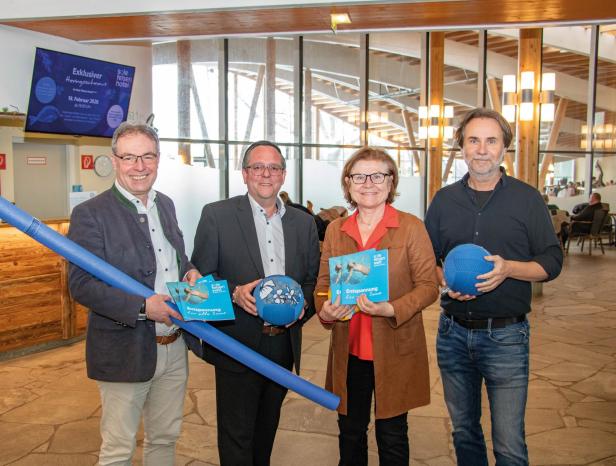 Drei Männer und eine Frau stehen im Eingangsbereich der Therme in Gmünd, sie halten Bälle und eine Schwimmnudel.