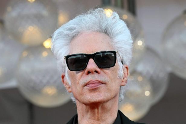 Jim Jarmusch mit silbergrauem Haar und dunkler Sonnenbrille blickt in die Kamera.
