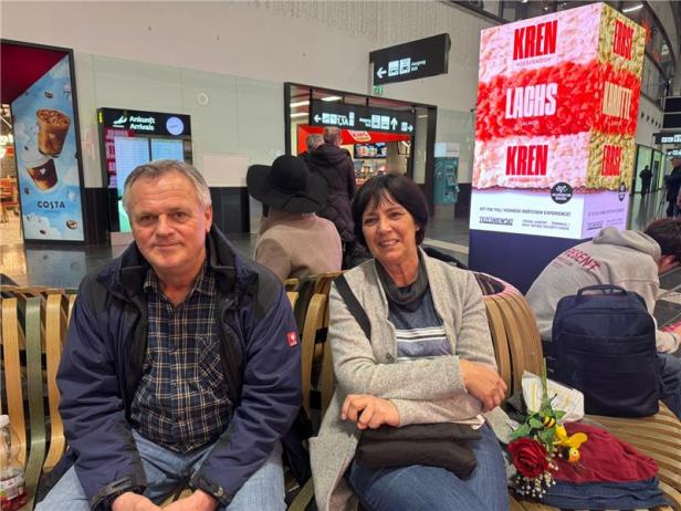 Ein Ehepaar wartet auf ihre Angehörigen am Flughafen Wien