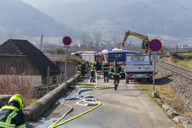 Die Feuerwehr bei den Löscharbeiten mit Schläuchen und Feuerwehrautos in Dürnstein.