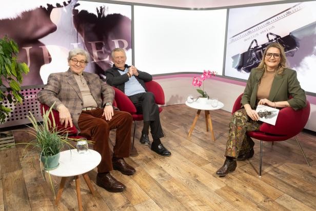 Drei Personen sitzen in einem TV-Studio