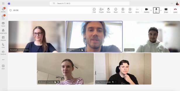 Fünf Personen in einem Videokonferenz-Call mit Namensbeschriftungen auf dem Bildschirm.