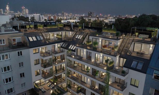 Mehrstöckiges Wohnhaus mit beleuchteten Balkonen und begrünten Dachterrassen in einer nächtlichen Stadtansicht.