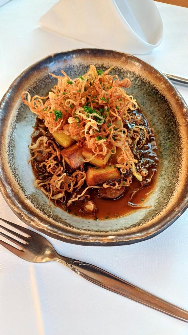 Ein Zwiebelrostbraten schön angerichtet auf einem Teller. 