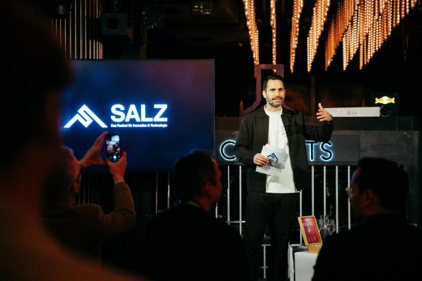 Ein Mann präsentiert beim SALZ-Festival auf der Bühne.