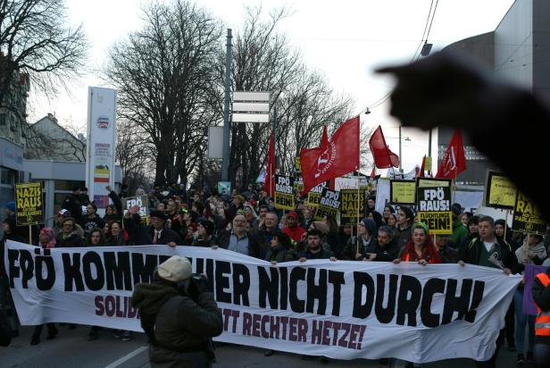 Eine Demonstration mit Transparenten gegen die FPÖ zieht durch die Straßen.