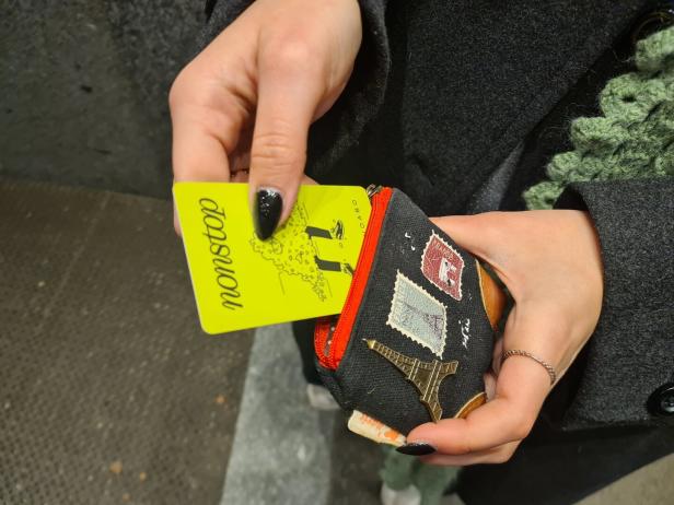 Ein Foto von einer Hand die eine Geldbörse und die Karte für das Nonstop-Kinoabo hält.