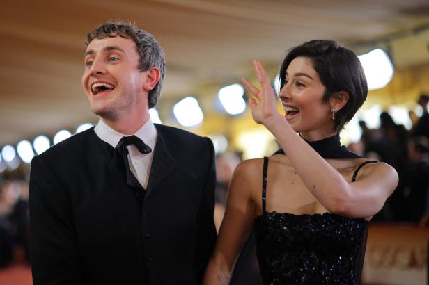 Paul Mescal und Gracie Abrams lachen und winken in die Menge.