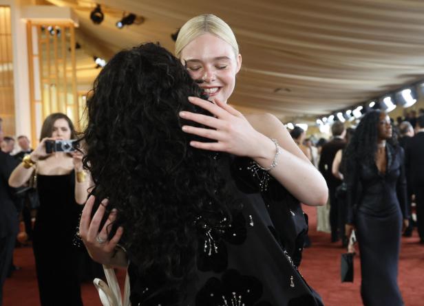 Elle Fanning umarmt herzlich Kollegin Odessa A’zion mit dunklen Locken auf dem roten Teppich.
