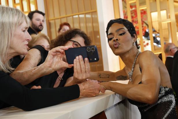 Eine Frau macht mit ihrem Handy ein Foto von Teyana Taylor, die einen Kussmund macht.