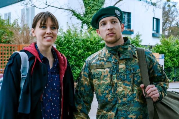 Szene aus "So haben wir dich nicht erzogen": Alina Schaller und Julian Pichler in Uniform und mit Barett stehen draußen.