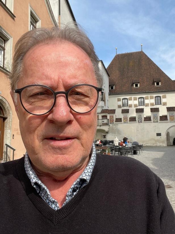Mann mit Brille auf einem Stadtplatz