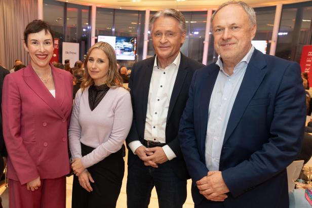 Vier Personen stehen nebeneinander bei einer Diskussionsveranstaltung im Saal.