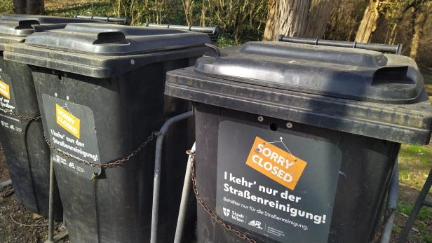 Mehrere schwarze Mülltonnen der Stadt Wien sind mit Ketten gesichert und mit "Sorry Closed" beschriftet.