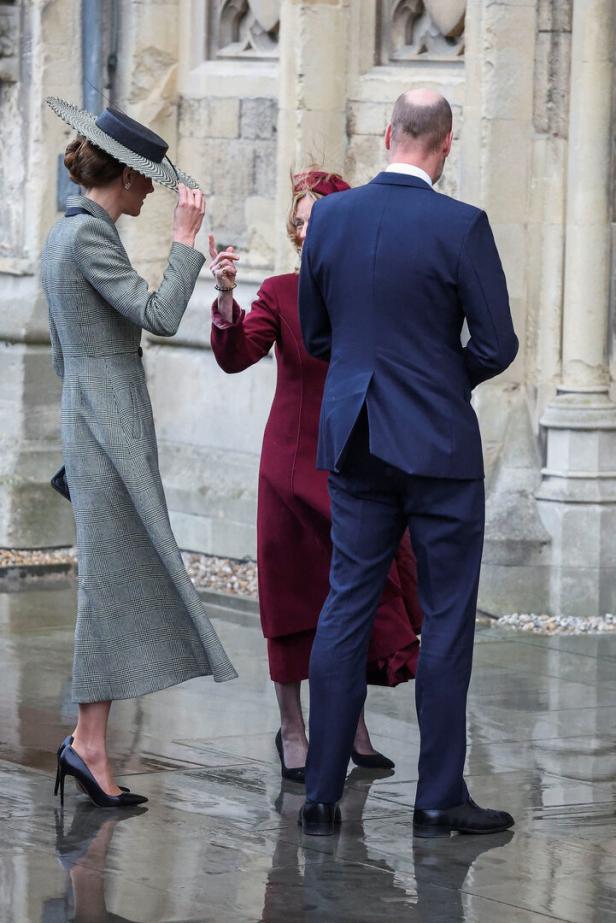 Kate, William und eine weitere Frau stehen vor einem Gebäude.