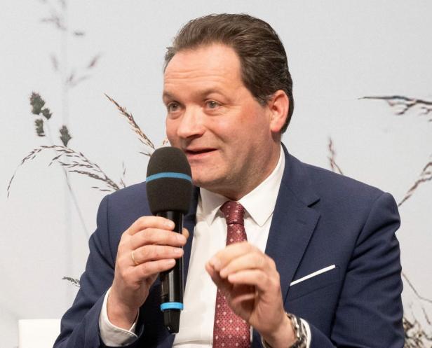 Ein Mann im Anzug mit Mikro 