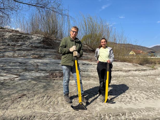 Seehofer und Sandbichler stehen mit ihrem Werkzeug auf einer Donauinsel und lächeln in die Kamera.