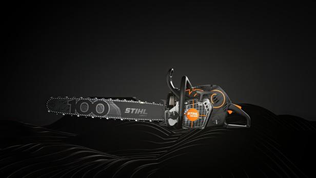Eine Stihl-Motorsäge mit schwarzem und orangefarbenem Design liegt auf einem dunklen, gewellten Untergrund.