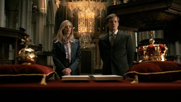 In einer Kirche stehen Máxima und Willem-Alexander, davor die Kronen.