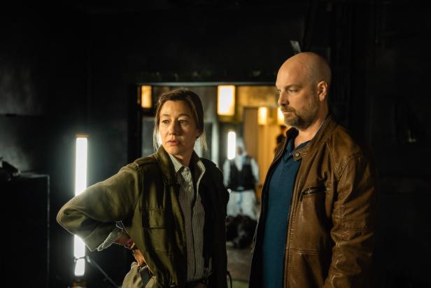 Johanna Wokalek und Stephan Zinner stehen als Ermittlerduo in einer düsteren Szene der Krimi-Reihe „Polizeiruf 110“ nebeneinander.