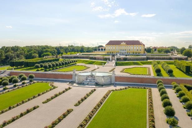 Barockgarten von Schloss Hof mit Springbrunnen, gepflegten Rasenflächen und symmetrischen Beeten.