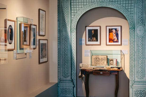 Ausstellungsraum mit gerahmten Porträts, Gartenplänen und historischen Dokumenten.