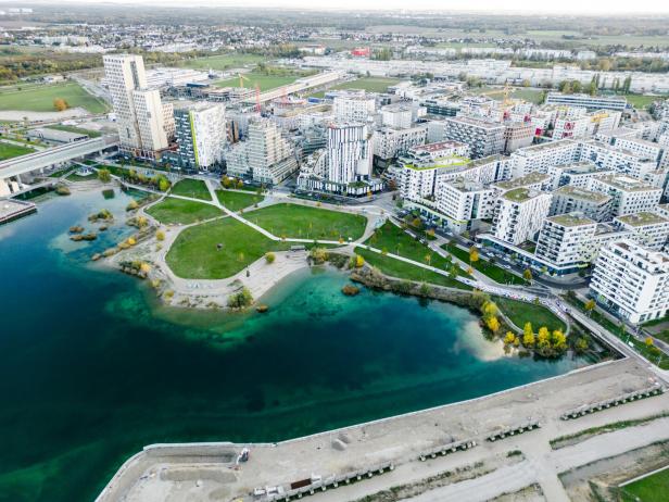 Wiener Seestadt in der Donaustadt: Luftaufnahme einer Stadtlandschaft mit See, Parks und modernen Wohngebäuden.