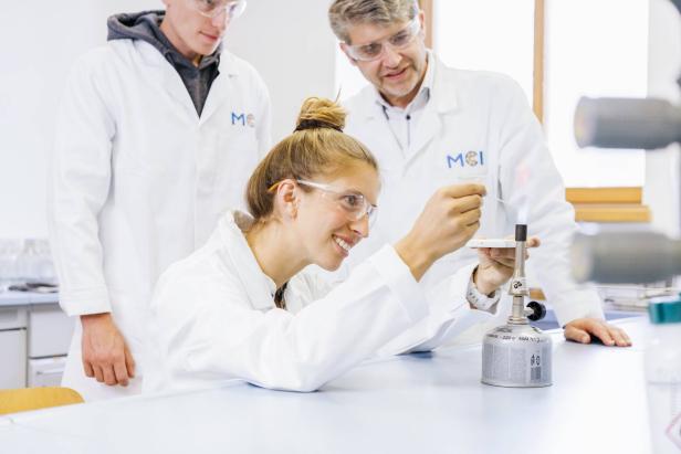 Studierende und Lehrende des MCI Innsbruck arbeiten gemeinsam im Labor an einem wissenschaftlichen Experiment.