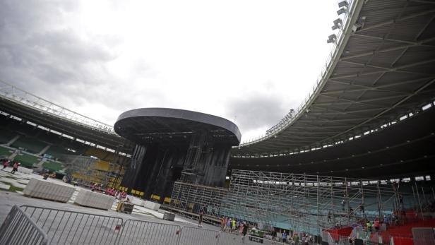 Im Inneren eines Stadions wird eine große Bühne aufgebaut.