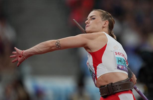 Eine Speerwerferin mit Tätowierung der olympischen Ringe bereitet sich auf den Wurf vor.