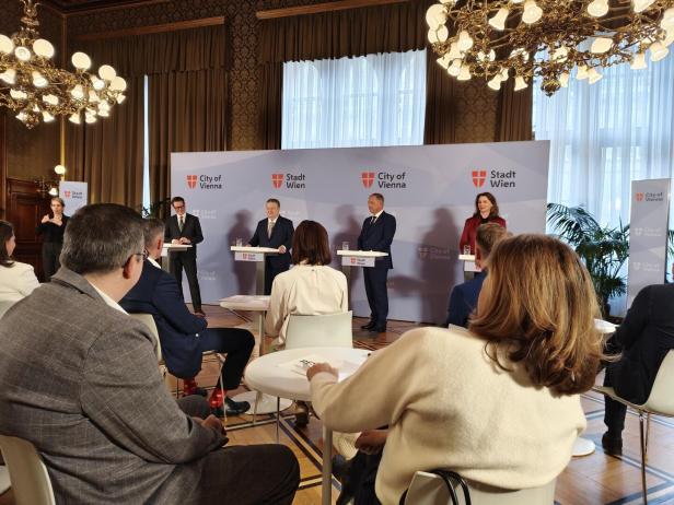 Drei Politiker und eine Politikerin präsentieren vor einem Publikum die Klima-Allianz.