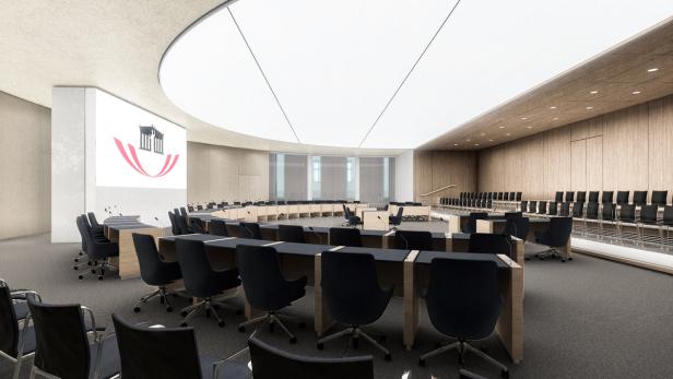 Ein Sitzungssaal mit Tischen in Hufeisenform und dem Logo einer Institution an der Wand.