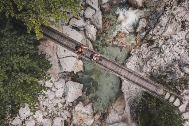Eine Luftaufnahme eines Paares, das über eine Holzbrücke geht.