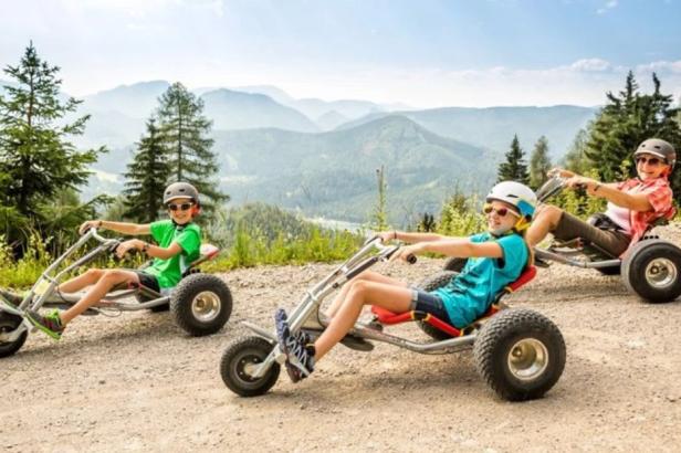 Drei Personen fahren auf vierrädrigen Go-Karts.