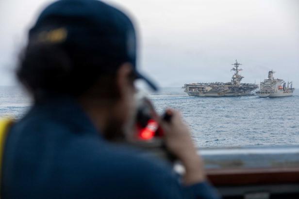U.S. Navy sailor looks out as Nimitz-class aircraft carrier USS Abraham Lincoln conducts a replenishment-at-sea